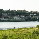 Vue d'un minaret et de maisons au bord de l'eau