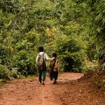 Deux enfants marchant sur un chemin en terre