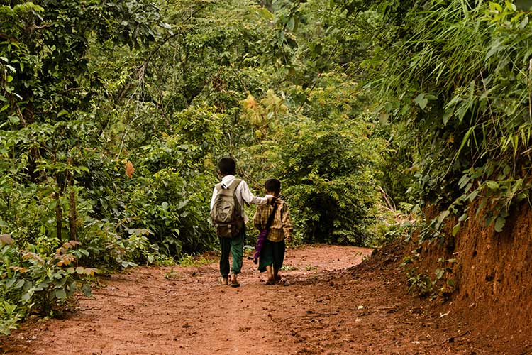 Deux enfants marchant sur un chemin en terre