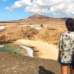 Une personne regardant une plage depuis une colline