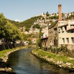 Rivière entourée de maisons et collines