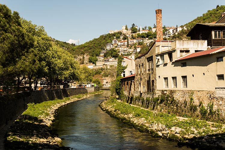 Rivière entourée de maisons et collines