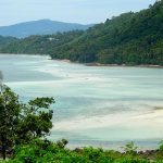 Plage entourée de collines verdoyantes