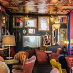 Un salon avec des sièges colorés et des miroirs