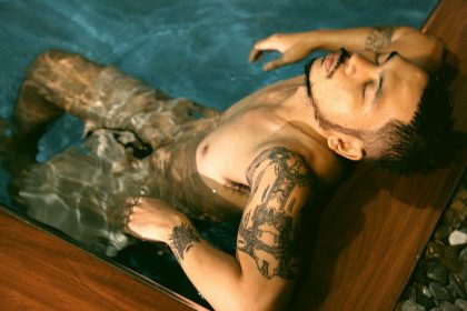 Homme tatoué se relaxant dans l'eau