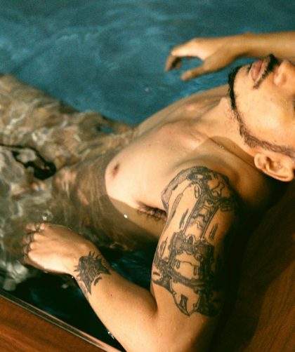 Homme tatoué se relaxant dans l'eau
