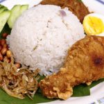 découvrez le nasi lemak, un plat malaisien emblématique à base de riz cuit dans du lait de coco, servi avec des accompagnements savoureux comme des anchois frits, des cacahuètes, des œufs durs et sambal. un voyage culinaire qui éveille vos sens !