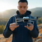 Un homme tenant un drone en pleine nature