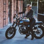 Femme en cuir sur une moto dans un environnement urbain