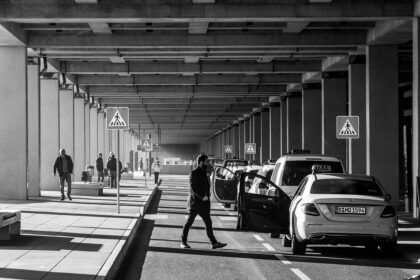 Une scène urbaine monochrome avec des piétons et des voitures