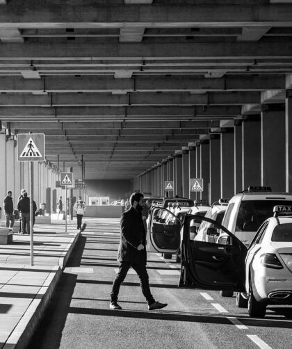 Une scène urbaine monochrome avec des piétons et des voitures
