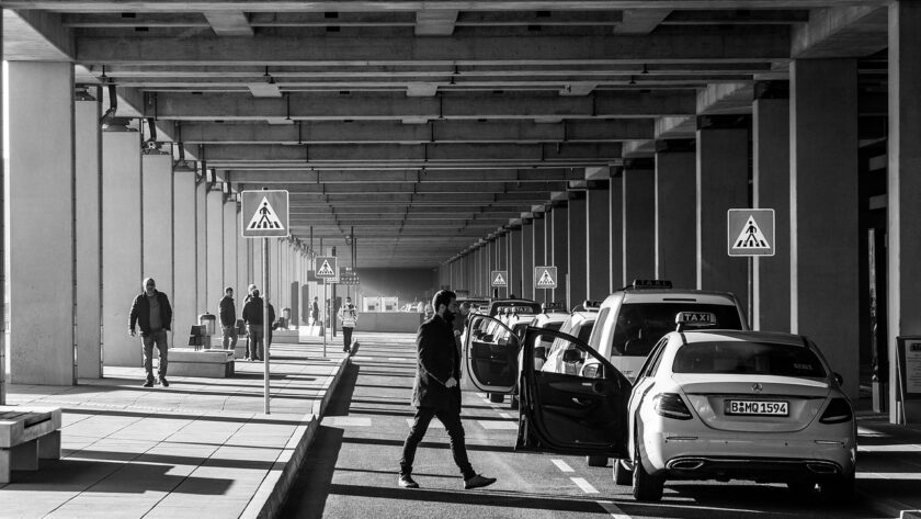 Une scène urbaine monochrome avec des piétons et des voitures