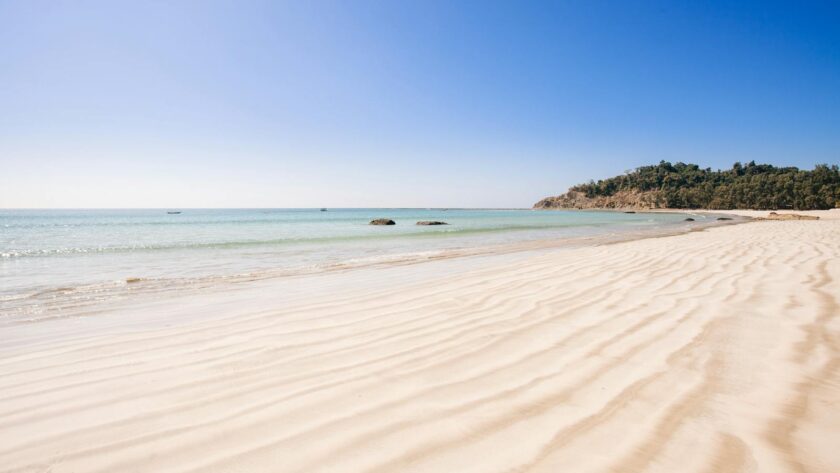 Une plage de sable avec de l'eau turquoise