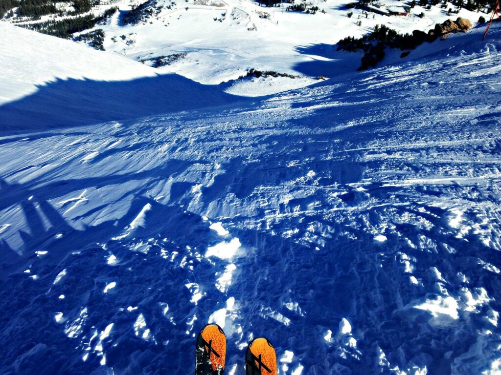 Skis pointés vers le bas sur une pente enneigée